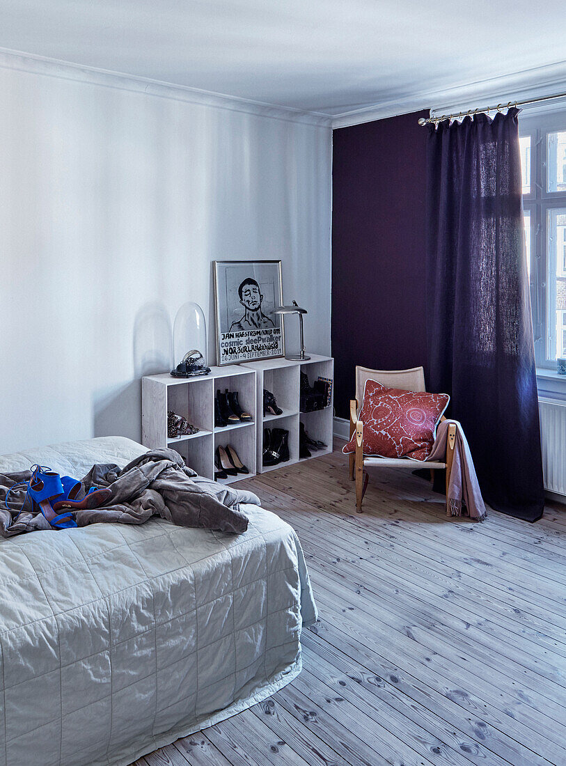 Bett, Regale und Stuhl im Schlafzimmer mit Holzdielenboden