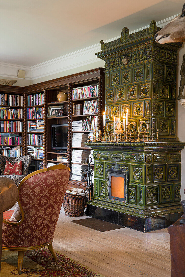 Green tiled stove and antique bookcase in the living room