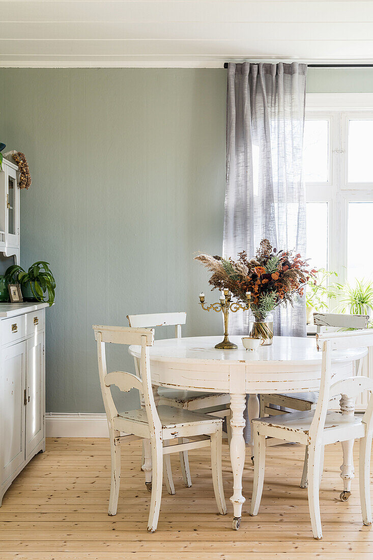 Shabby-chic table and chairs in dining room with wooden floor