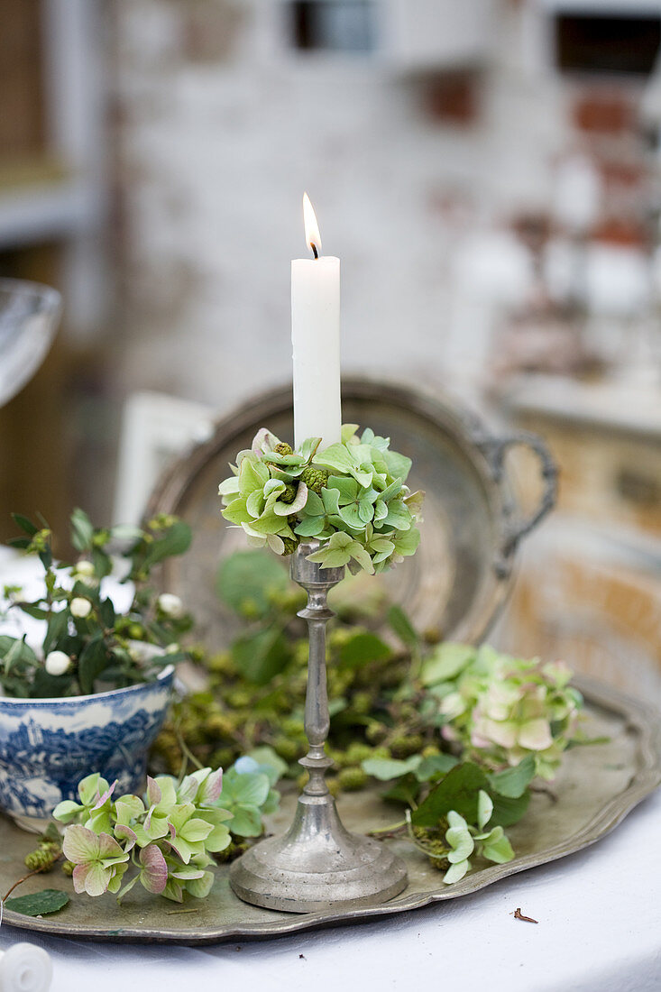 Silberner Kerzenständer mit grünen Hortensien als nostalgische Deko