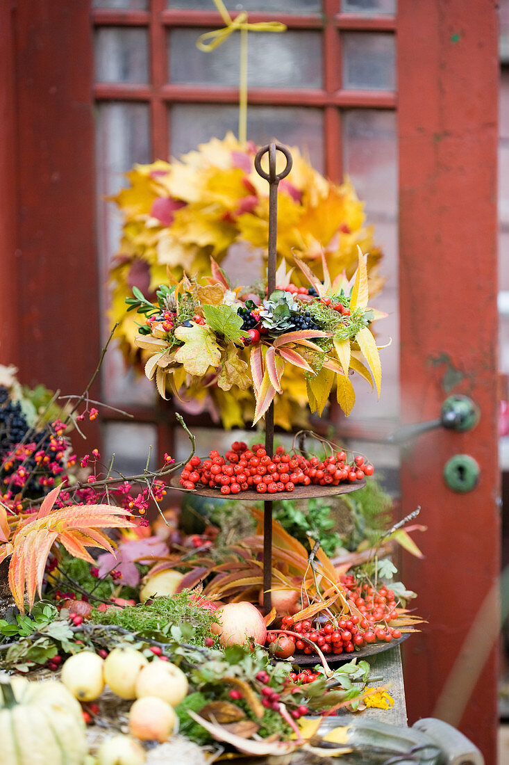 three tiered dessert stand with an autumn wreath of autumn leaves and berries