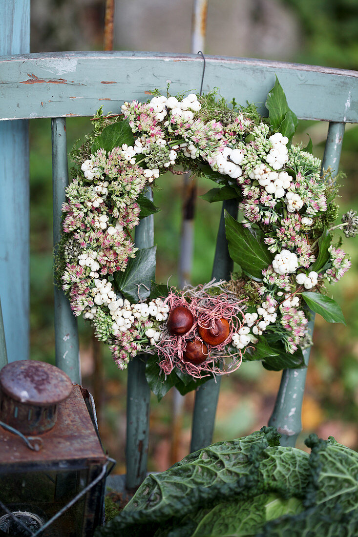 Autumn wreath made of ivy, sedum, and snowberries with tulip bulbs