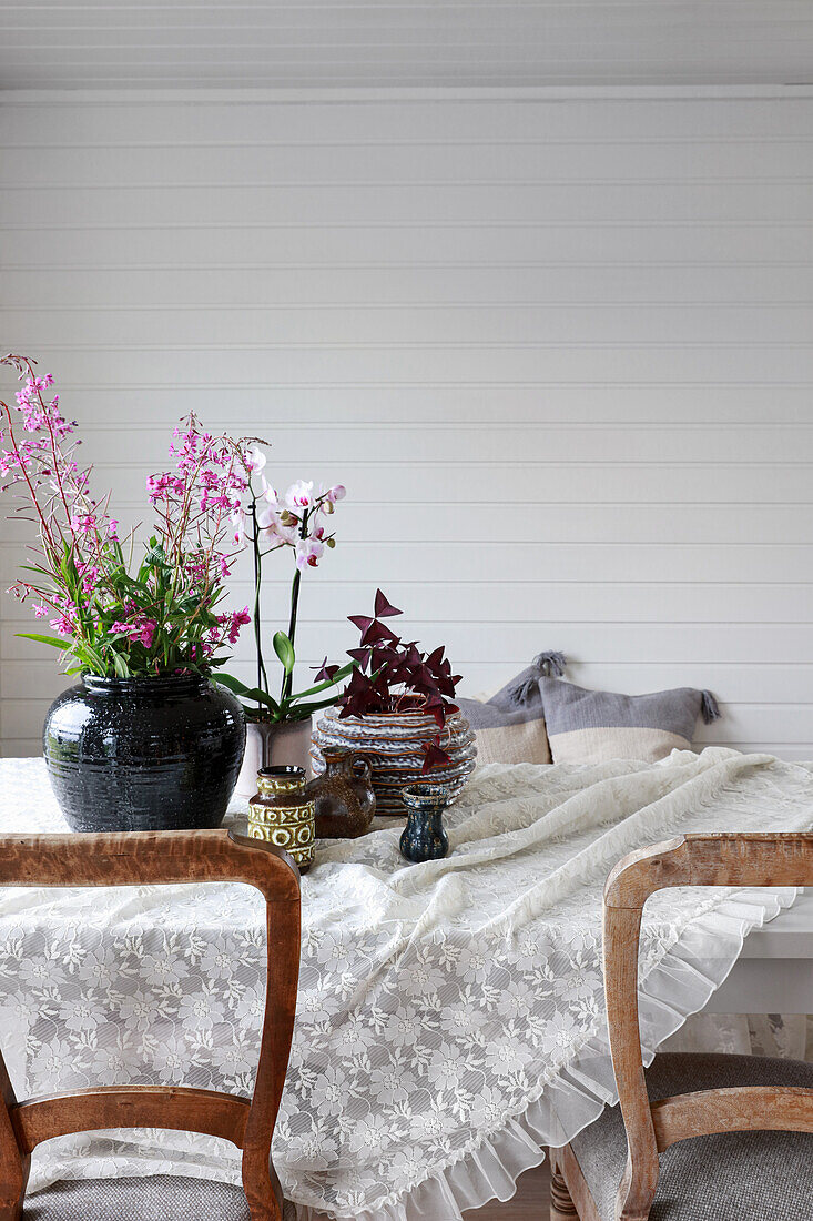 Esstisch mit rustikalen Stühlen im Zimmer mit weiß lackierter Holzverkleidung