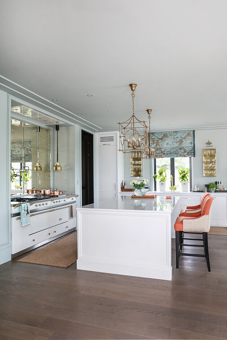 White island counter and designer chairs in elegant, open-plan kitchen