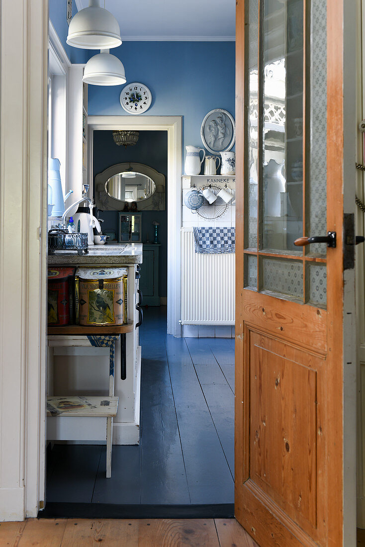 View through open door into blue-and-white, vintage-style kitchen