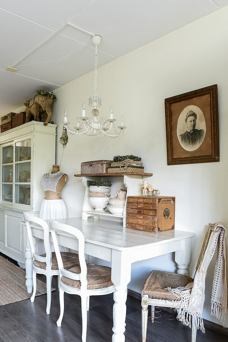 Old chairs at white wooden table in shabby-chic dining room