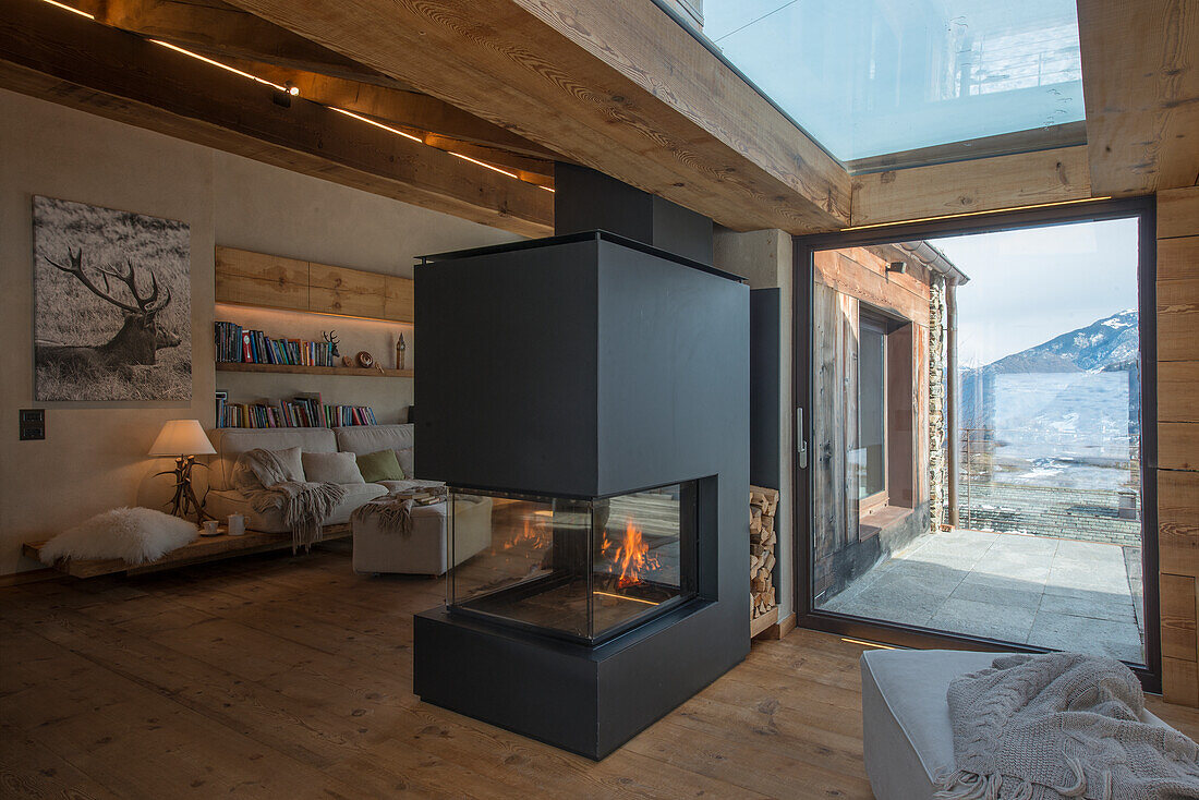 Fireplace next to patio door in open-plan interior with wooden floor
