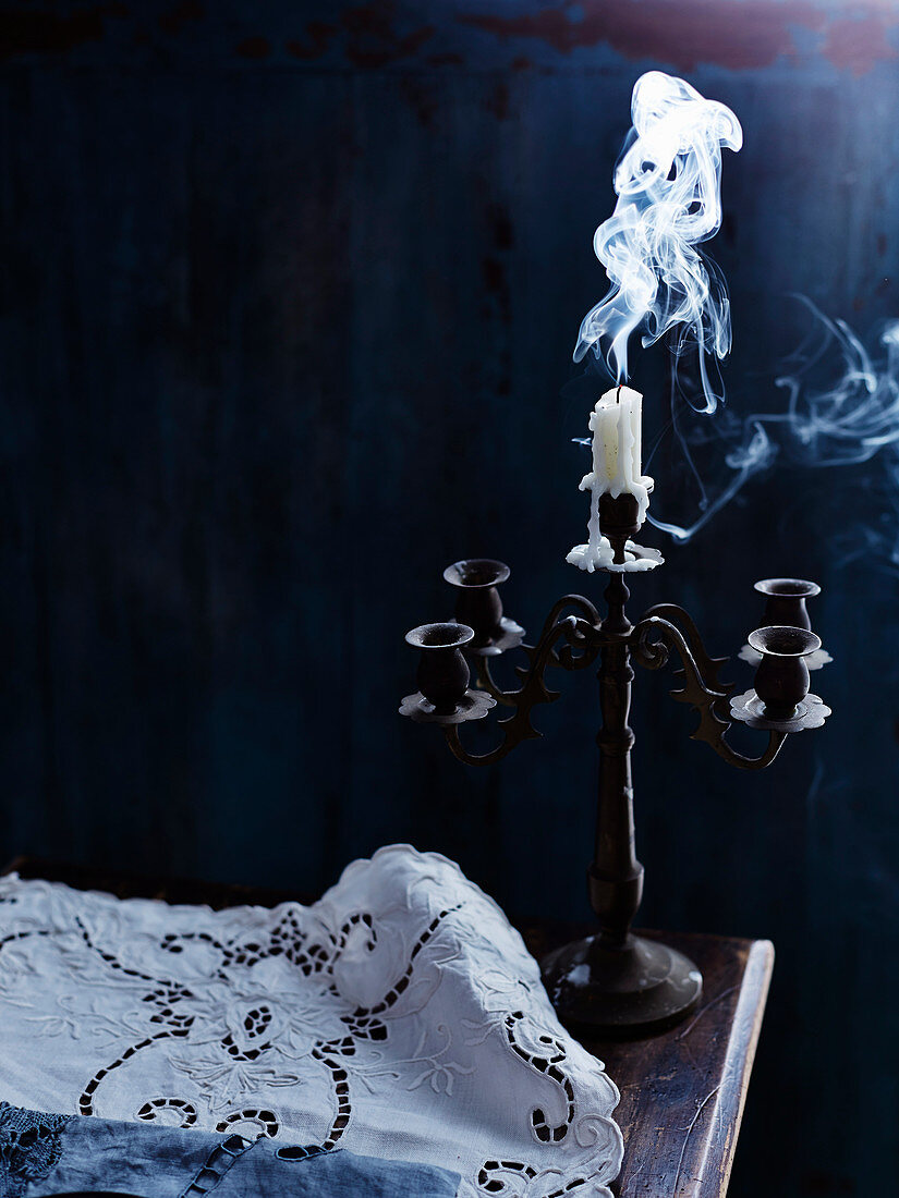 Smoking extinguished candle in vintage candelabra