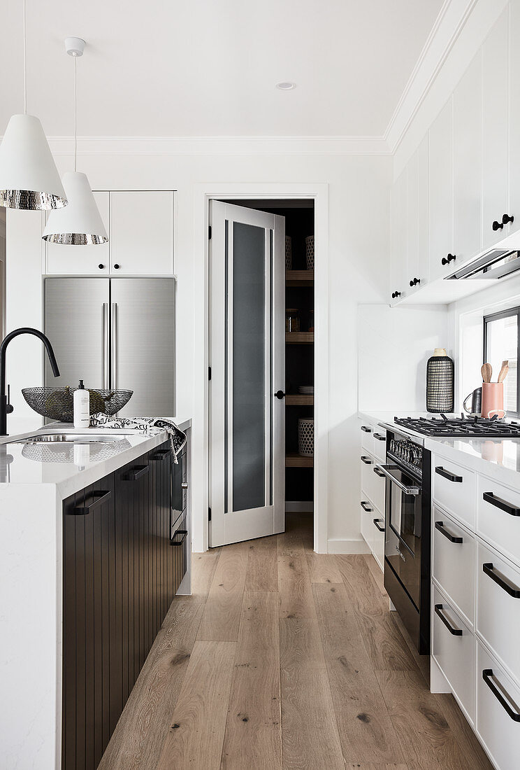 Offene Tür zur Vorratskammer in klassischer Küche in Schwarz-Weiß