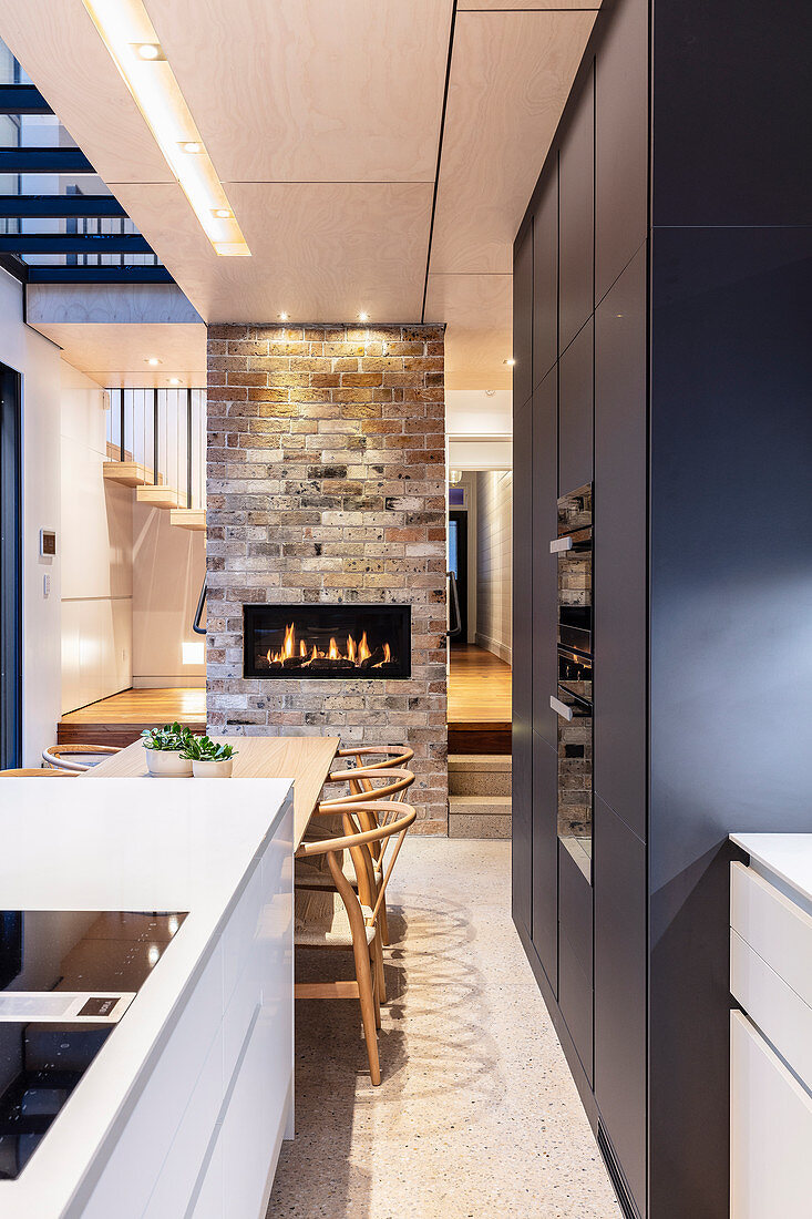 Modern kitchen with kitchen island, dining table and fireplace
