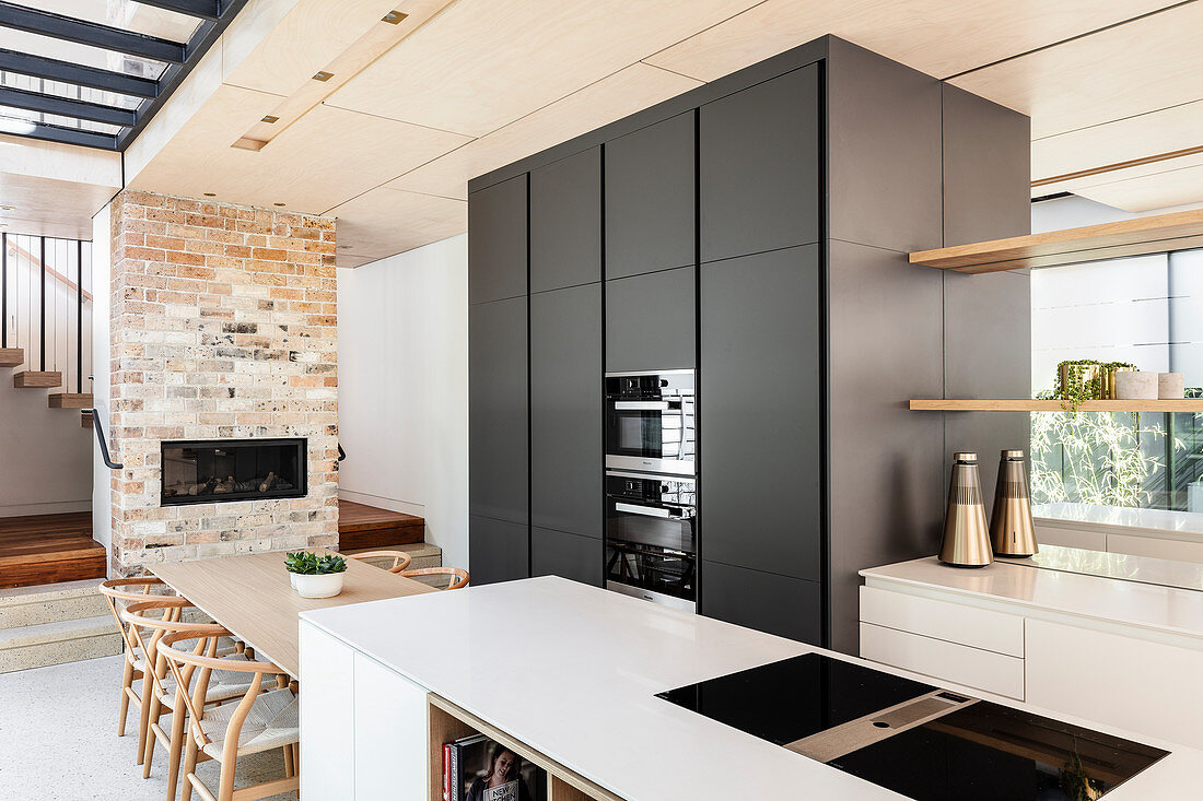 Moderne Wohnküche mit verspiegelter Wand und Kaminofen