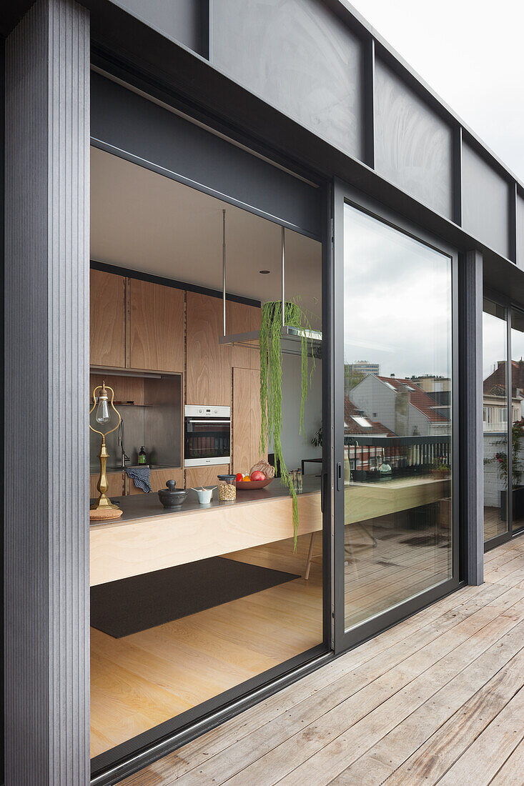 Blick von der Terrasse durch geöffnete Glasschiebetür in offene Küche