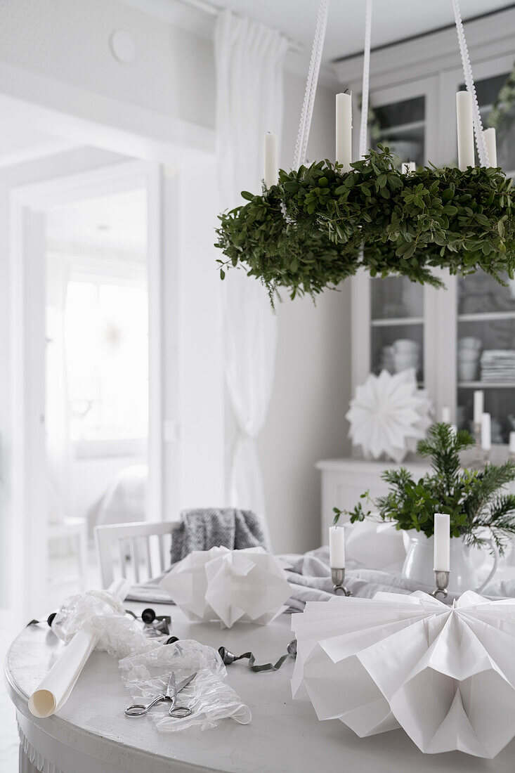Festively set dining table below suspended Christmas wreath