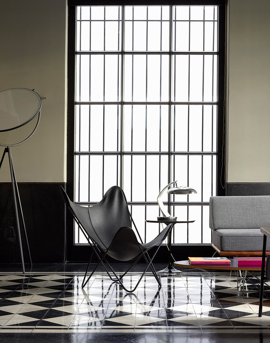 Designerstuhl vorm Sprossenfenster im Wohnzimmer im Designerstil