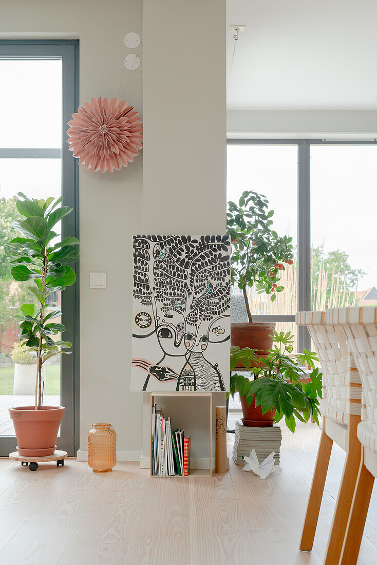 Decor with picture, books and plants in the light-flooded dining room