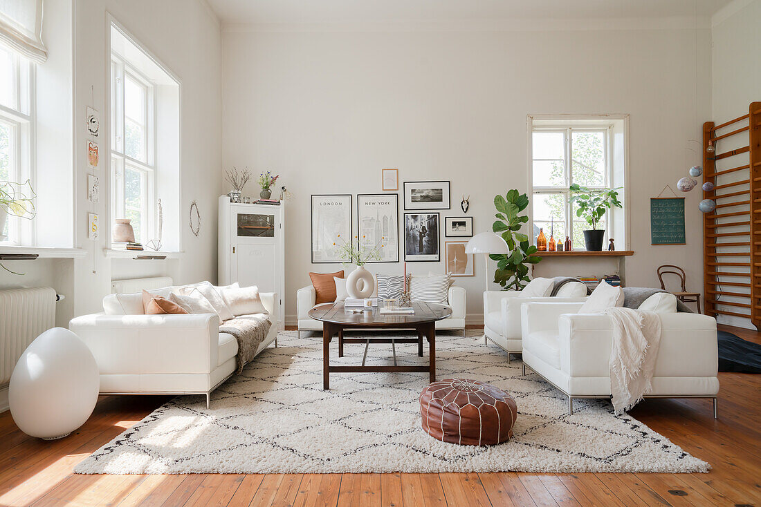 White leather sofa and arm chairs around a coffee table