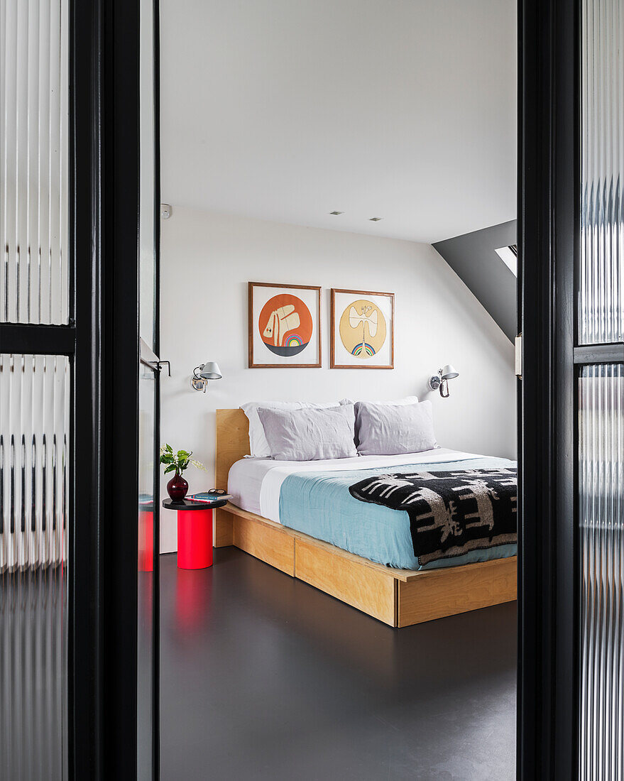 Blick durch geöffnete Glastür in minimalistisches Schlafzimmer