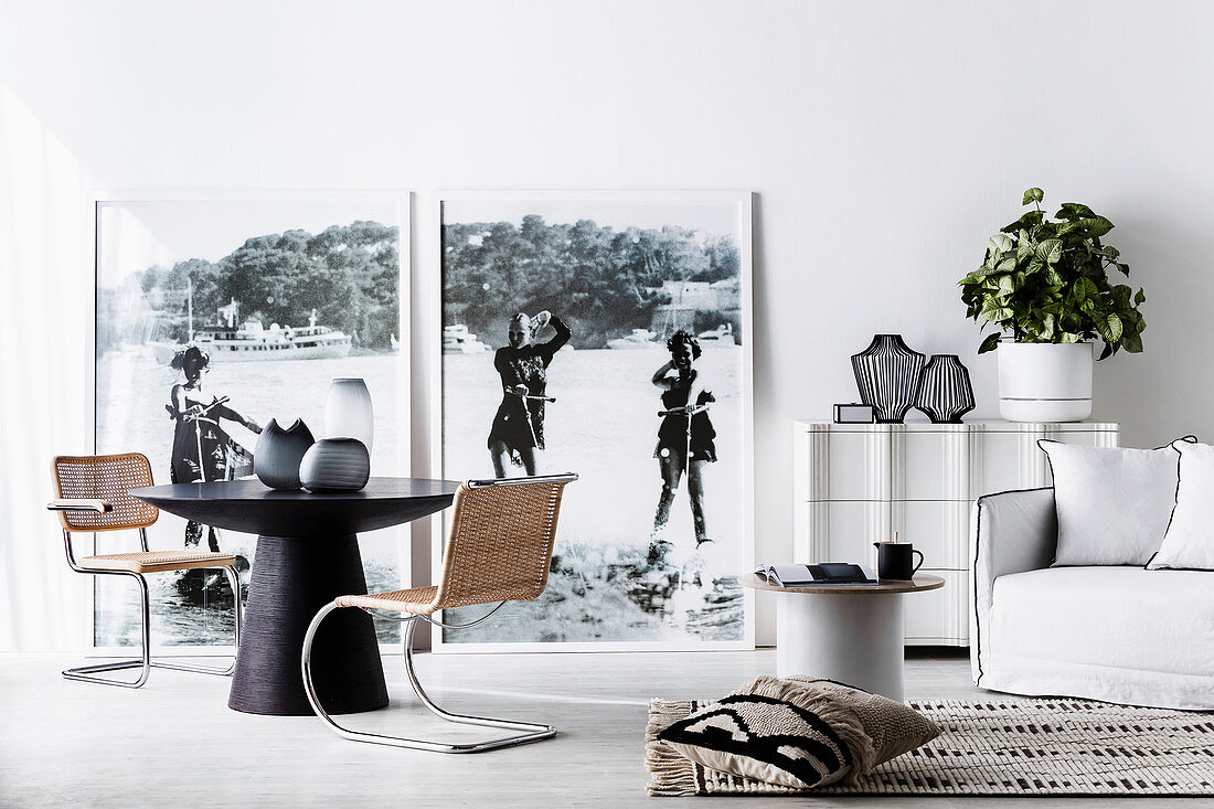 Round designer table with cantilever chairs in front of photo posters