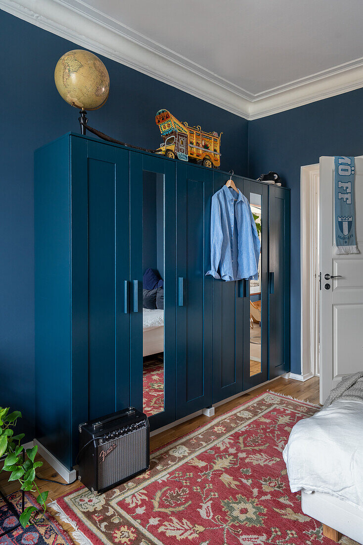 Petrolfarbener Keiderschrank mit Spiegeltüren im Schlafzimmer mit blauen Wänden