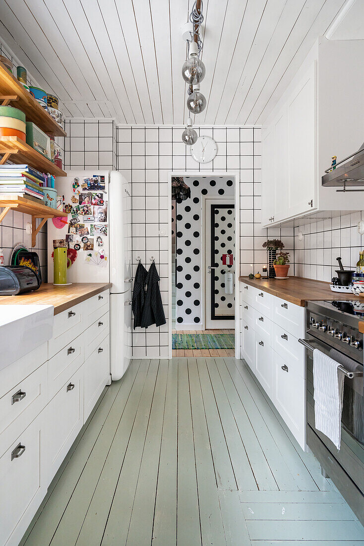 Grey floorboards in white country-style kitchen