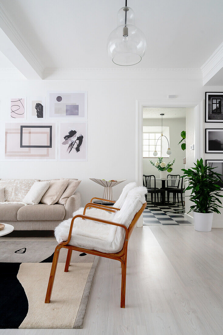 Armlehnstühle mit Tierfell, Sofa und moderne Kunst im Wohnzimmer