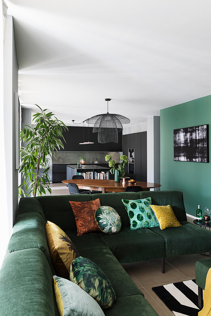 Green corner sectional sofa with cushions in open plan living space