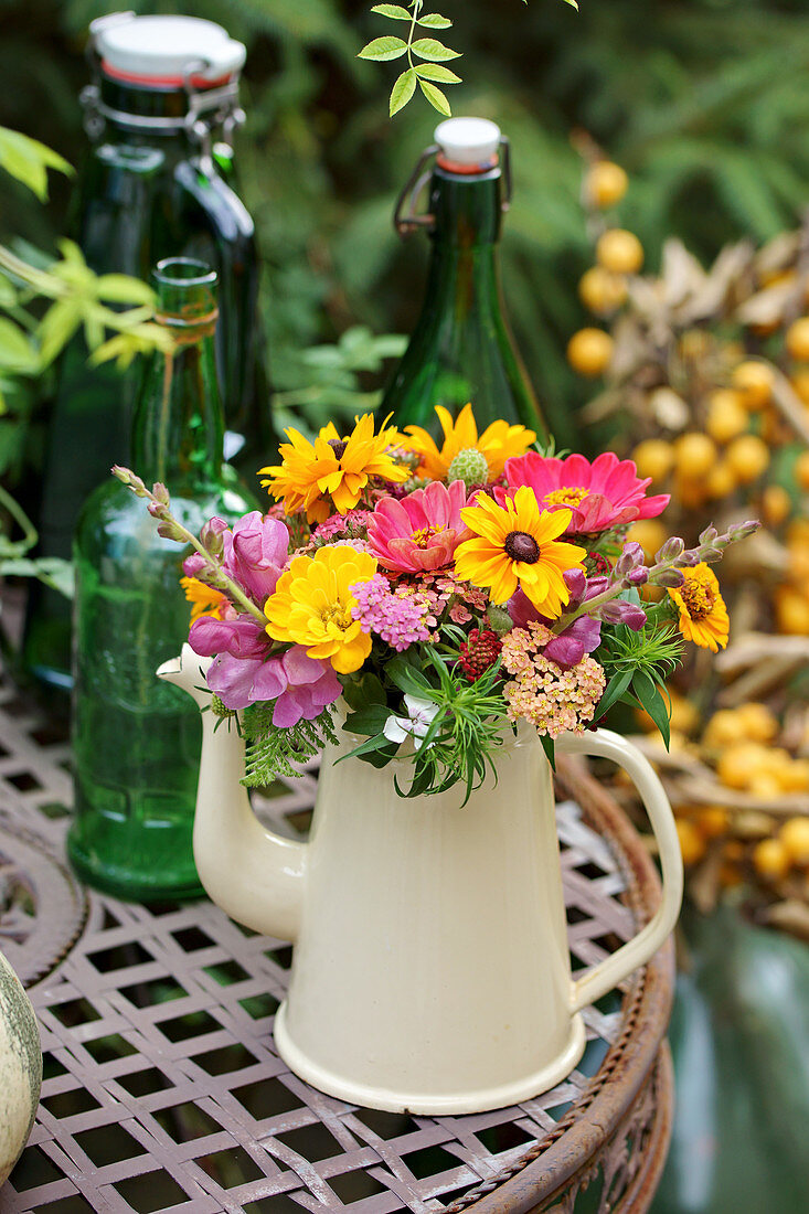 Colorful summer bouquet of coneflower, zinnia, yarrow, snapdragon, and widow's flower in a pot