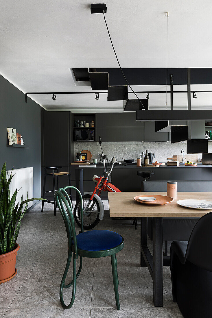Dining area in front of a black fitted kitchen cabinets with a kitchen island