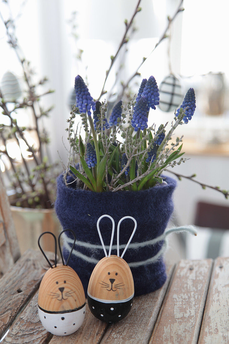 Easter arrangement of grape hyacinths in felt collar and wooden Easter bunnies