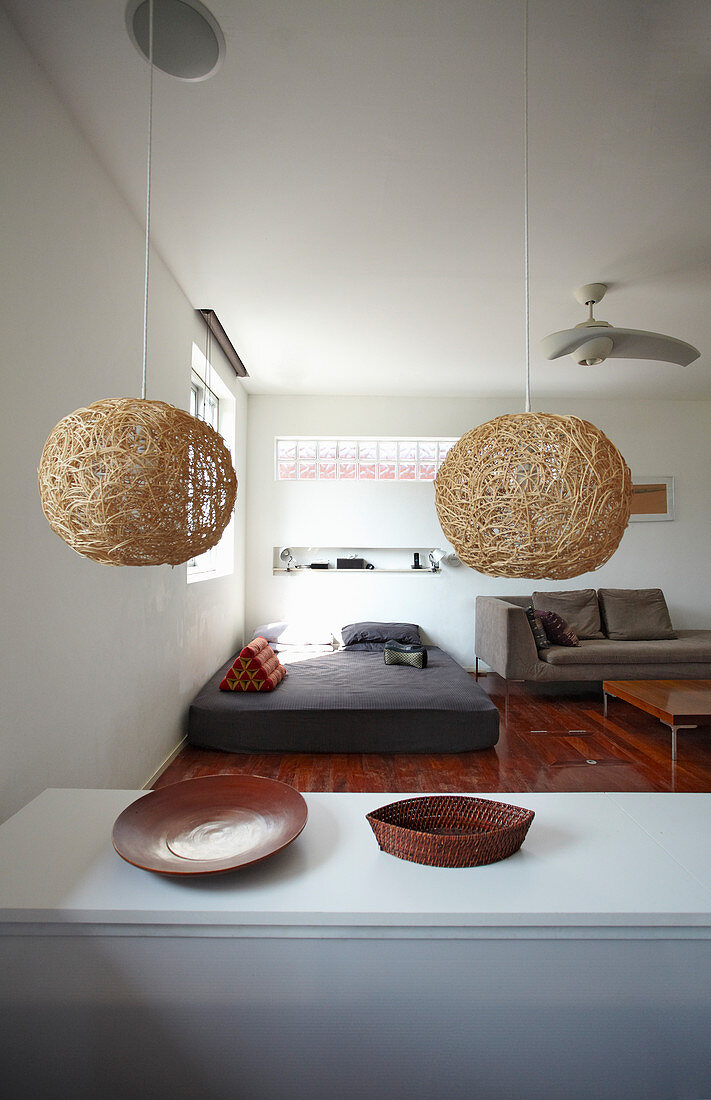 Pendant lamps above kitchen counter and view into living area with teak floor