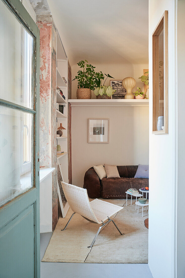 Blick ins Wohnzimmer mit Designerstuhl, Sofa und Regal