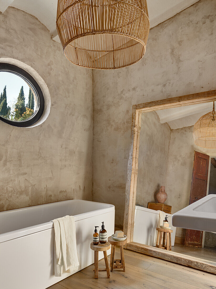 Großformatiger Spiegel und Badewanne im Badezimmer mit sandfarbenen Wänden