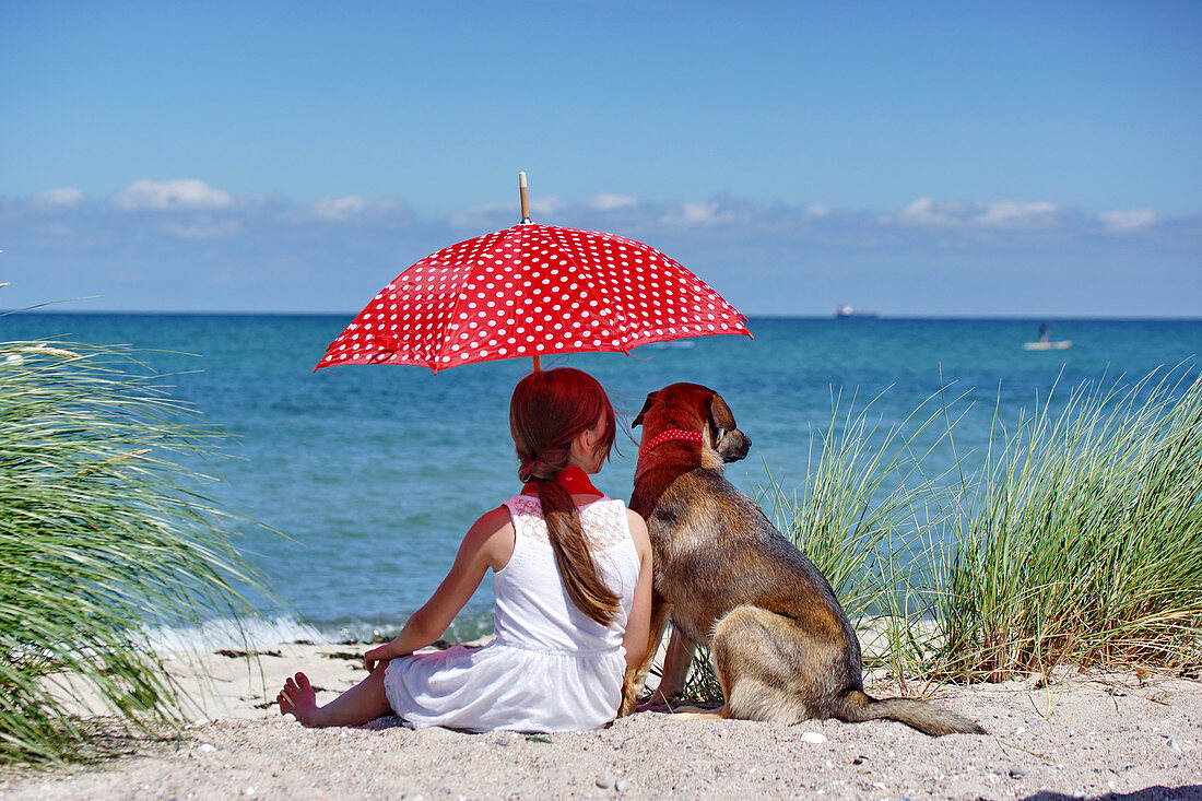 Mädchen mit Sonnenschirm und Hund am … – Bild kaufen – 13423971