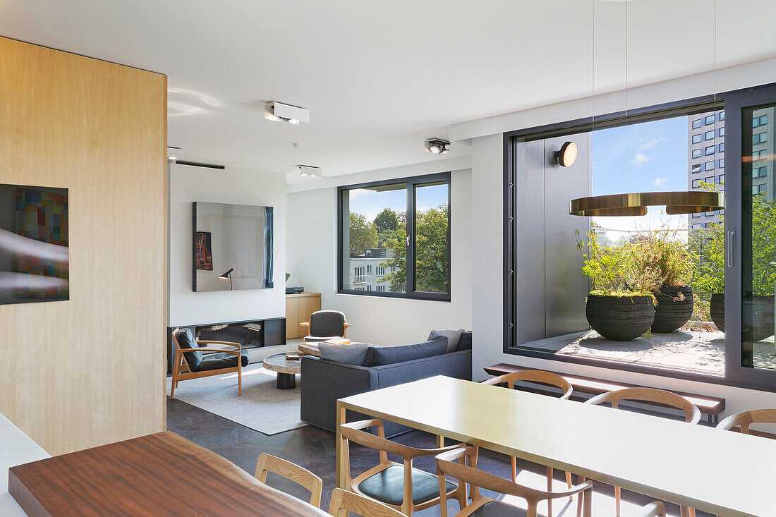 Offener Wohnraum mit Essbereich und Lounge und Glasschiebetür zur der Terrasse