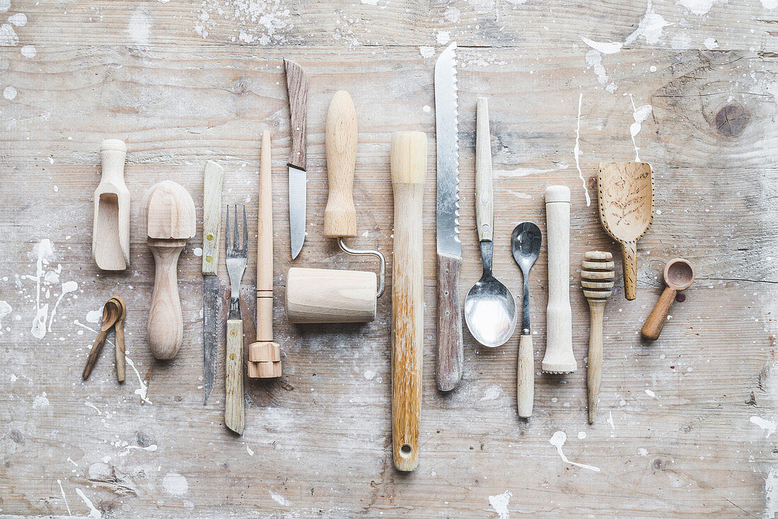 Various kitchen tools with wooden handles on a wooden board