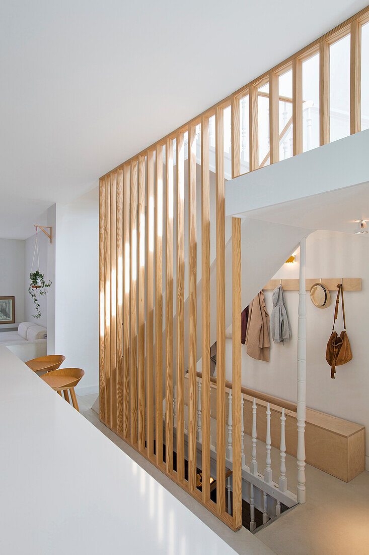 Bright room with white walls and wooden slats in the staircase area