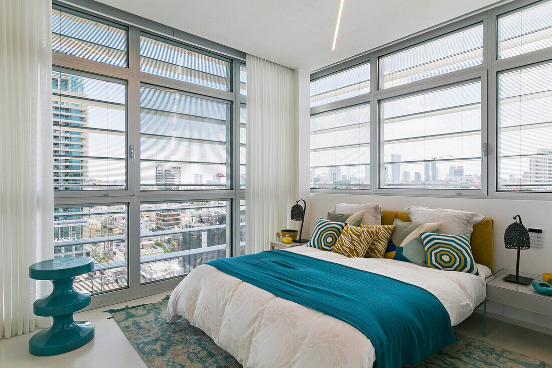 Double bed in bedroom with floor-to-ceiling windows in luxury penthouse