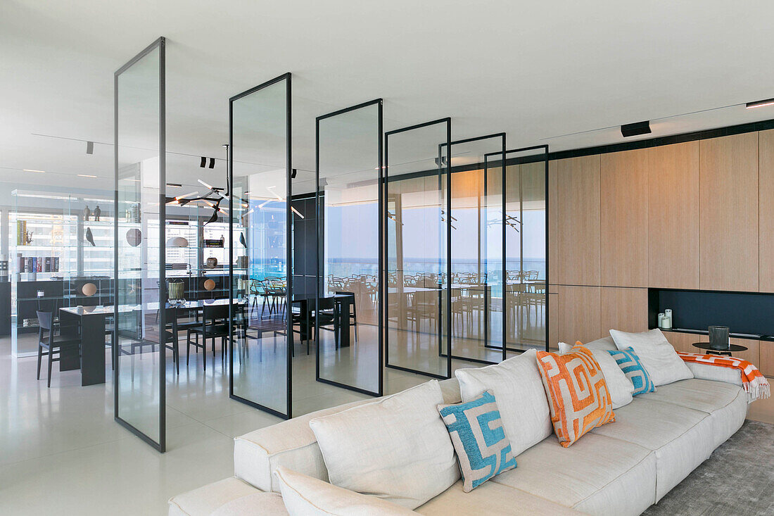 Raumteiler aus Glas zwischen Lounge und Essbereich in einem Luxus-Penthouse