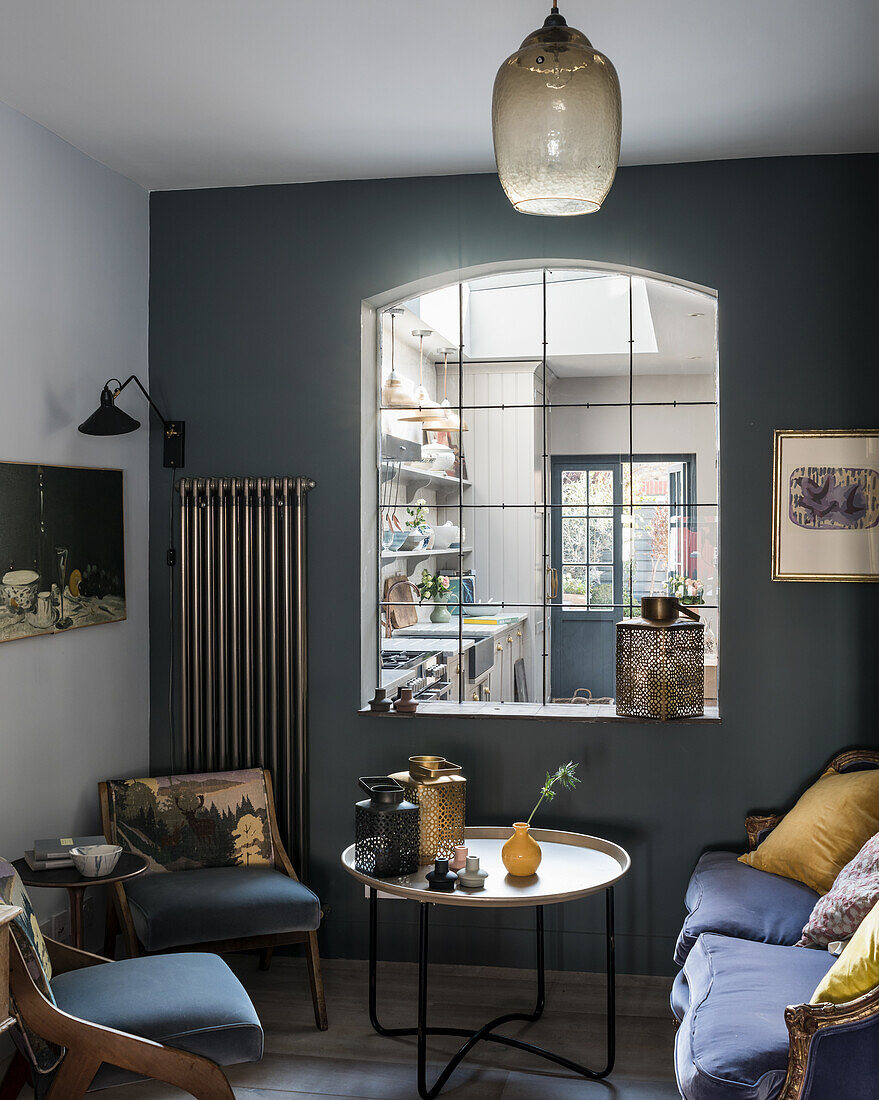 Cosy sitting room with plush velvet cushions and window through to kitchen, glass ceiling shade and the Moroccan table lamp