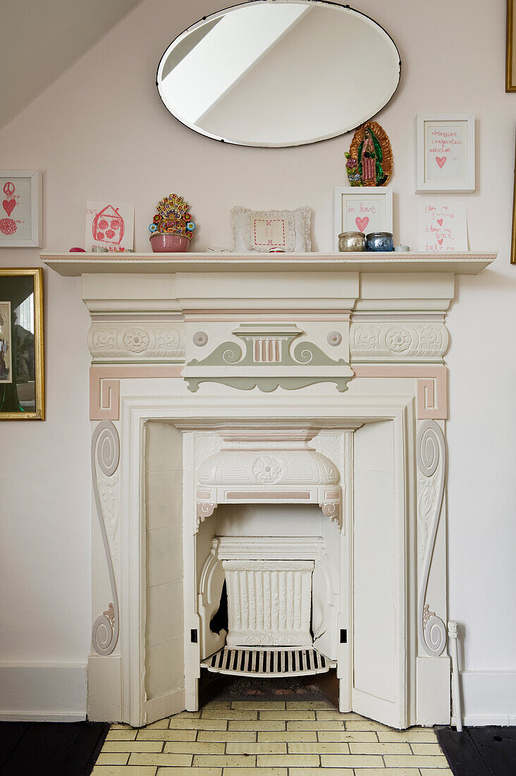 An original victorian fireplace painted in tones of cream and pink