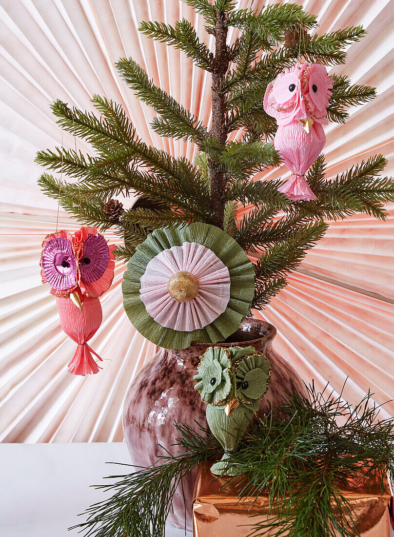 DIY paper decoration: Owls and blossom made of crepe paper on a fir branch
