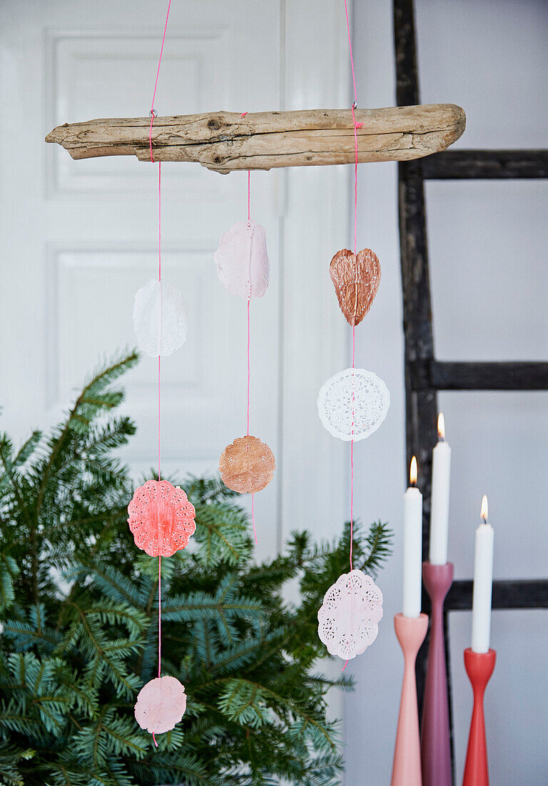DIY Christmas decorations made from baking parchment hung from driftwood