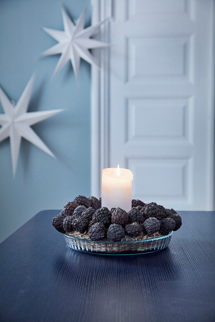 Candle with wreath of closed conifer cones