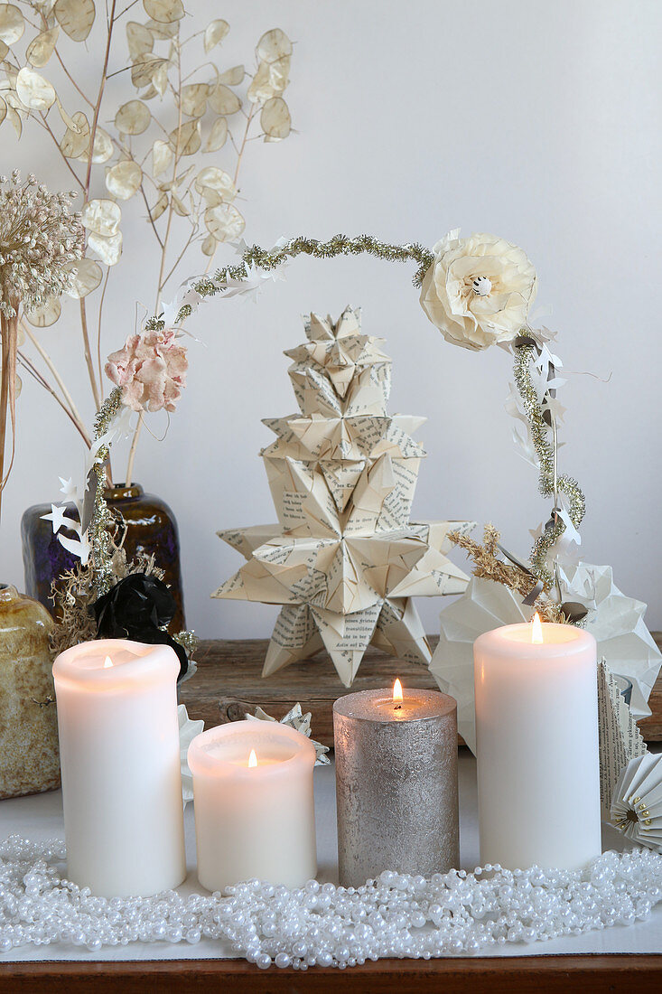 Advent arrangement with a Bascetta star hand-folded from book pages and candles