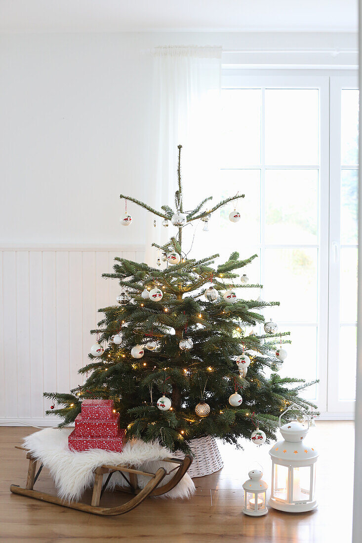 Weihnachtsbaum mit Weihnachtsdeko und antikem Schlitten
