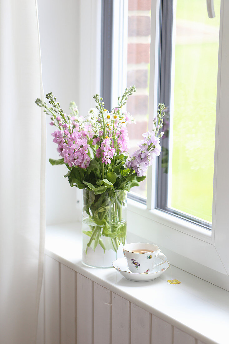 Bouquet of stocks and feverfew on the windowsill