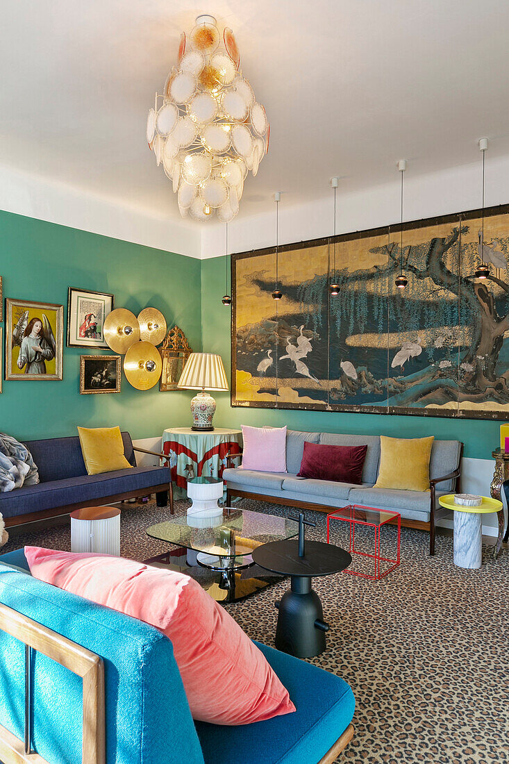 Seating furniture and large-scale artwork in salon with green walls