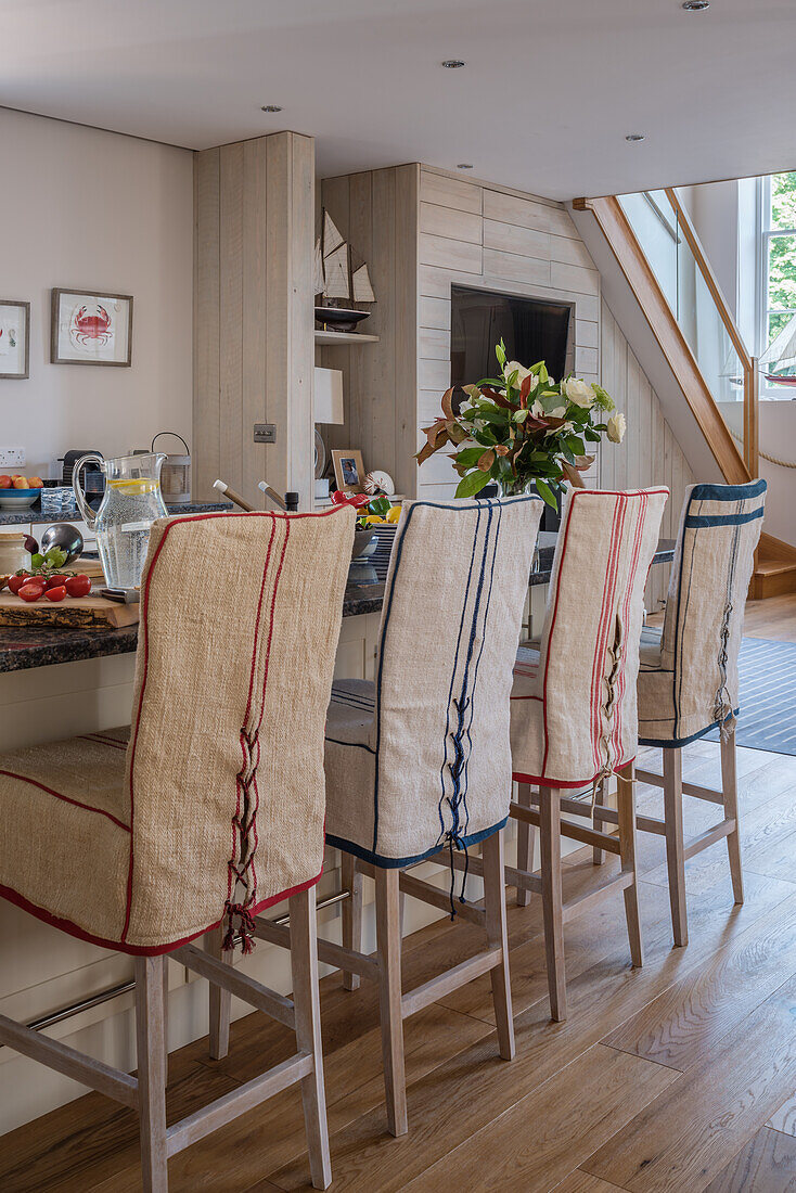 Chair covers in maritime nautical style at the kitchen island in open kitchen