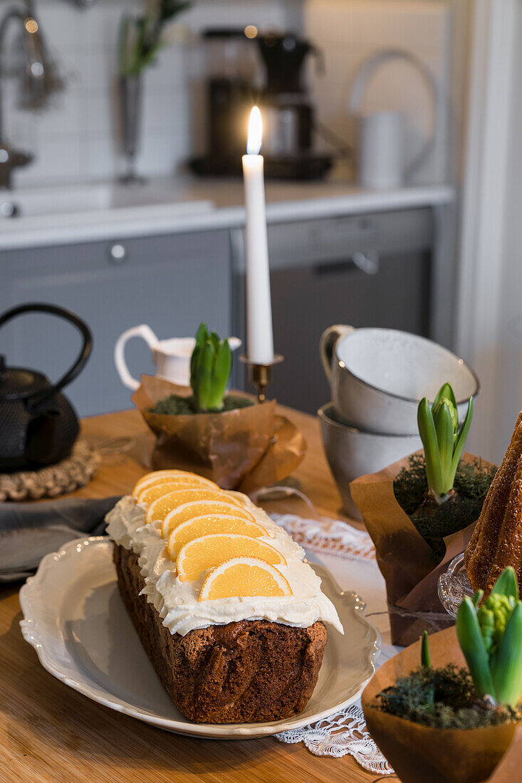 Kuchen mit Zitronenscheiben auf gedecktem Tisch mit Hyazinthen