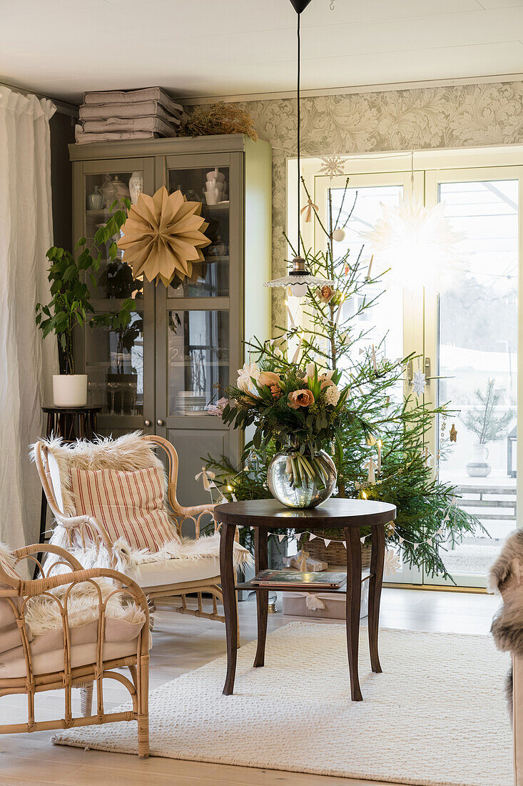 Gemütliches Wohnzimmer mit Blumenstrauß und Weihnachtsbaum